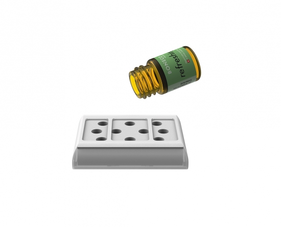Ätherisches Öl in gelbem Fläschchen neben einem weißen Aromatherapie-Diffuser