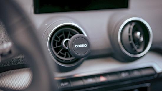 Ooono Verkehrsalarm im Auto-Lüftungsschlitz Nahaufnahme eines Ooono Geräts in einem Auto-Lüftungsschlitz, kleines rundes Gerät zur Verkehrsüberwachung.