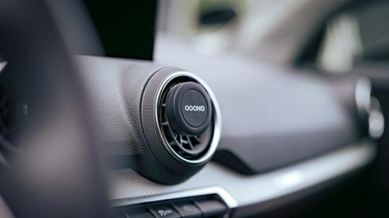 Ooono Verkehrsalarm im Auto installiert Nahaufnahme eines Ooono Verkehrsalarms an einem Lüftungsgitter im Auto