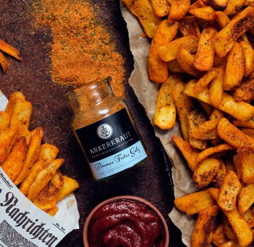 Ankerkraut Pommes Frites Salz mit knusprigen Pommes Ein Glas Ankerkraut Pommes Frites Salz neben goldbraun gebackenen Pommes und einer Schale Ketchup