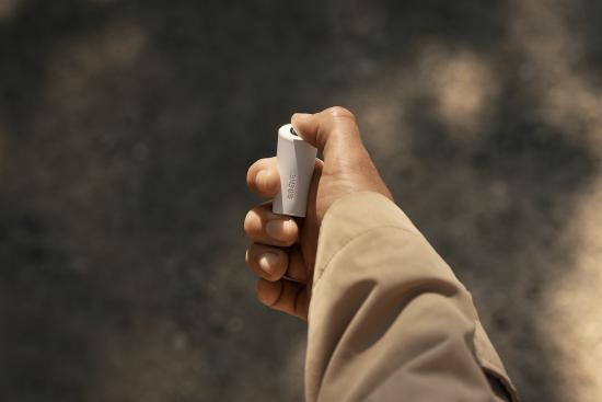 Hand hält einen kleinen weißen Inhalator im Freien Nahaufnahme einer Hand mit einem kleinen weißen Inhalator im Freien