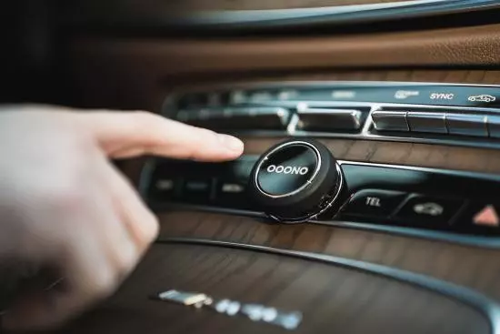 Nahaufnahme eines Fingerstreichs über einem modernen Auto-Interface mit digitaler Anzeige